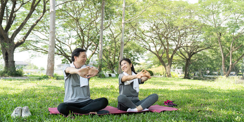 Couple Stretching Together in a Green Park. Embracing Wellness.