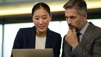 Two businesspeople focused on a laptop one with a surprised expression the other thoughtful - Powered by Adobe