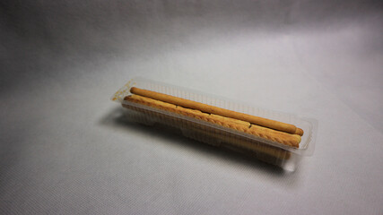 Plastic tray of biscuit sticks isolated on white background with shadow, packaged snack food concept