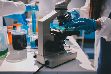 Scientist pipetting medical samples into microplate in laboratory
