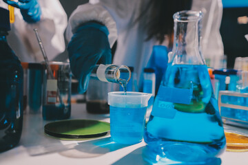 Scientist pipetting medical samples into microplate in laboratory