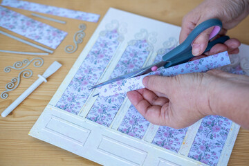 Hands meticulously cutting floral paper, Engaging in relaxing and creative DIY crafting activity, hobbyist at work, artistic activity