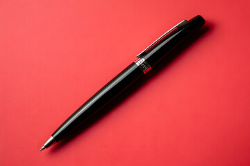 A Sleek Black Luxury Pen Displayed Against a Vibrant Red Background 