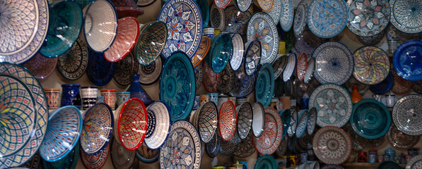 Moroccan ceramic plates, traditional pottery and market culture, local shop in Marrakech’s Medina, vibrant souks filled with traditional Moroccan detailed patterns and cultural artistry