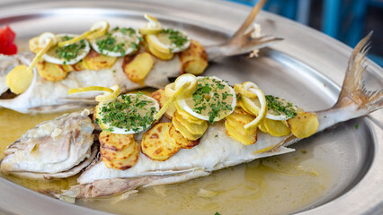 Blue fish sea bream pezzogna baked with potatoes and lemon. Italian Mediterranean cuisine