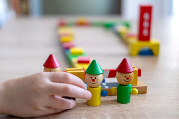 Child playing with wooden toys, play time, Colorful blocks and figures on table. Early education, fine motor skills concept