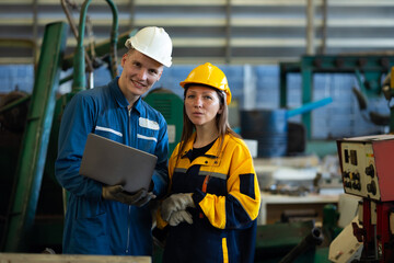 working woman : Caucasian mele and female manufacture technical or factory staff working with holding laptop computer standing at industry factory. Professional Mechanical Engineer