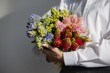 Elegant arrangement of multicolored hyacinths held by caucasian female adult