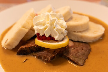 Traditional Czech Dish Svíčková with Dumplings, Cranberries, and Cream