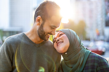 Portrait of happy muslim couple embracing each other in the city
