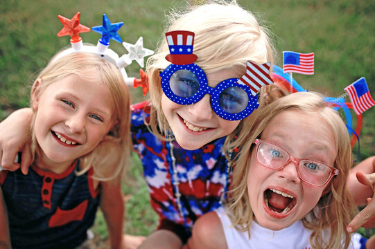 Happy and Smiling Patriotic Little Kids Sitting at a Fourth of July Parade in USA - Powered by Adobe