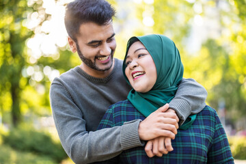 Portrait of happy muslim couple embracing each other in the city
