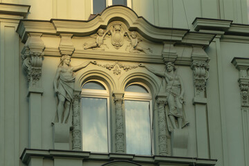 This architectural feature showcases detailed statues on a window with intricate designs,...