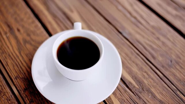 Rotating coffee cup on wooden table in relaxing atmosphere