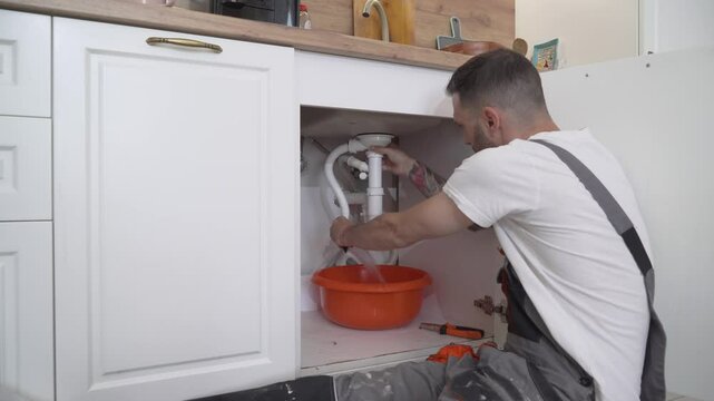 Water Leak Repair by Plumber Under Sink with Leaking Drain Pipe