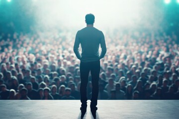 A man stands on a stage in front of a crowd of people
