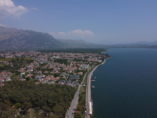 A serene aerial view of Lake Köyceğiz in Turkey on a calm summer day, showcasing tranquil blue waters, lush surroundings, and peaceful natural beauty.
