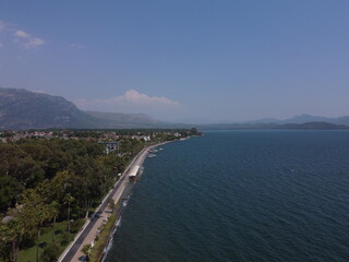 A serene aerial view of Lake Köyceğiz in Turkey on a calm summer day, showcasing tranquil blue waters, lush surroundings, and peaceful natural beauty.