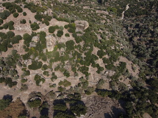 A drone view of South Türkiye's arid, Mediterranean-like hills with terra tones and sparse vegetation, captured during a scenic summer road trip