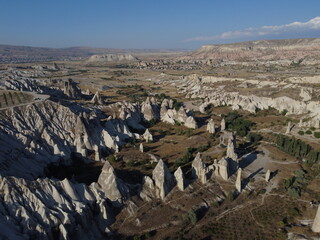 A stunning drone shot over Love Valley in Cappadocia, showcasing its iconic rock formations, surreal landscape, and warm tones under a clear sky.