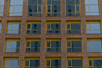 Modern building facade with yellow window frames in urban setting