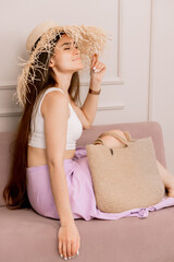 Smiling beauty woman in a white top with a stylish woven tote bag
