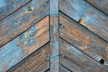 Weathered wooden planks in a chevron pattern, a rustic and aged background.