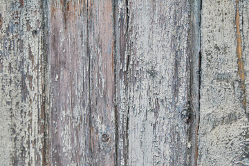 Close-up of weathered wood planks with peeling paint for a rustic aesthetic.
