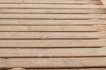 Wooden decking on the beach, close-up on the boards. Boardwalk. Background. Weathered wooden boards...