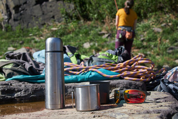 Climber's equipment ready on a rock surface, with a person in the background.