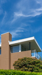 Top of grey stucco luxury house with shingle roof, green trees and nice windows in Spring in Vancouver, Canada, North America. Day time on May 2025.
