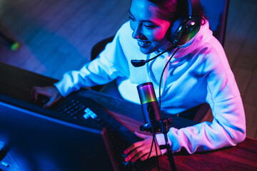 Charming gamer chat streaming live in neon-lighted ambiance, engaging moments of cyber gaming fun in digital space