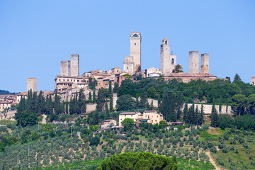 San Gimignano village, Italy: green countryside, blue sky, hill panorama with town and towers