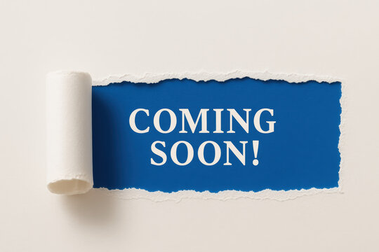 An anticipation future developments is revealed as a torn paper edge uncovers a bold message promising upcoming opportunities and progress