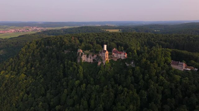 Panoramic drone view of Lichtenstein Castle in southern Germany. Romantic 19th-century architecture, nestled in lush greenery on a mountain ridge. Luftaufnahme Schloss Lichtenstein Wuerttemberg. 