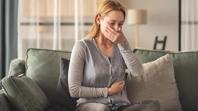 Young woman feeling nauseated at home