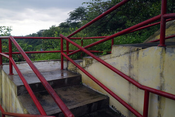 Concrete Stairs with Red Handrails After Rain