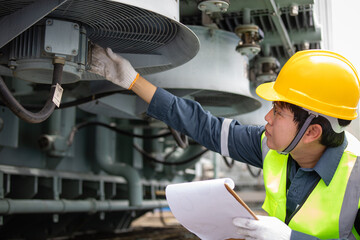 Engineer performs inspection on transformer cooling system at substation ensuring safety and...