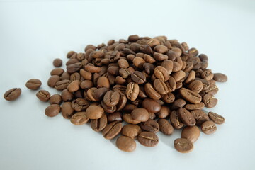 Dark brown coffee beans with a white background