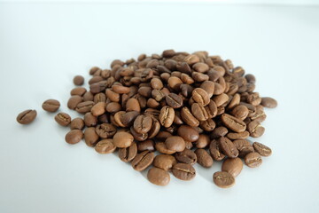 Dark brown coffee beans with a white background