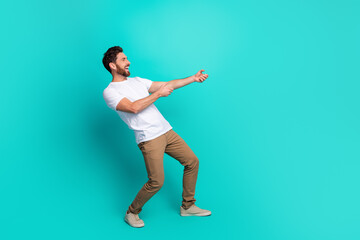 Energetic young man in casual wear gesturing dynamically against a vibrant turquoise background