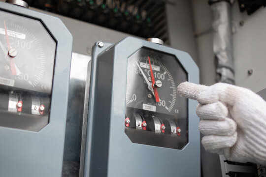 Temperature gauge inside substation shows power levels while wind outside affects transformer performance in this industrial setting