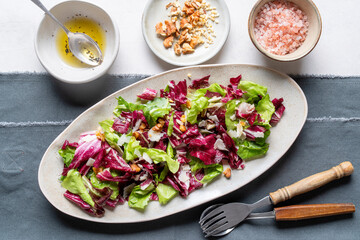 A light appetizer or an elegant side dish. Salad prepared with a mix of different varieties of leaves, enriched with walnuts and parmesan shavings.
