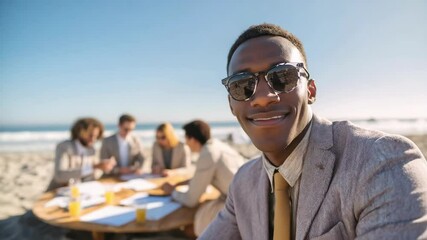 Confident young man in suit and sunglasses attending an outdoor business meeting on the beach with colleagues in background.
- Powered by Adobe