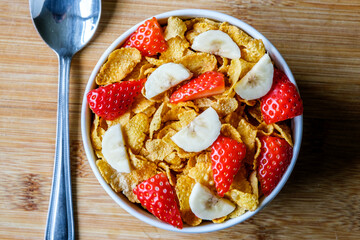 Bowl Of Classic Corn Flakes Breakfast Cereal With Fresh Strawberries And Banana
