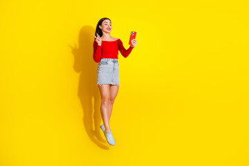 Cheerful Young Woman in Casual Summer Fashion Taking a Selfie Against Bright Yellow Background