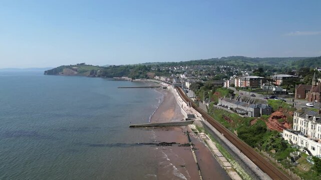 Dawlish, Devon, England: DRONE VIEWS: Flying alongside the railway track, the drone shows seafront properties arriving at the town quay and railway station. Dawlish is a popular UK holiday destination