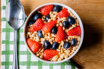 Bowl Of Classic Rice Krispies Breakfast Cereals With Fresh Strawberries And Blueberries