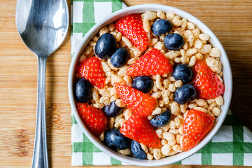 Bowl Of Classic Rice Krispies Breakfast Cereals With Fresh Strawberries And Blueberries