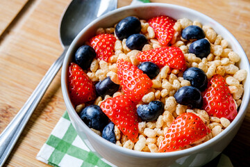 Bowl Of Classic Rice Krispies Breakfast Cereals With Fresh Strawberries And Blueberries